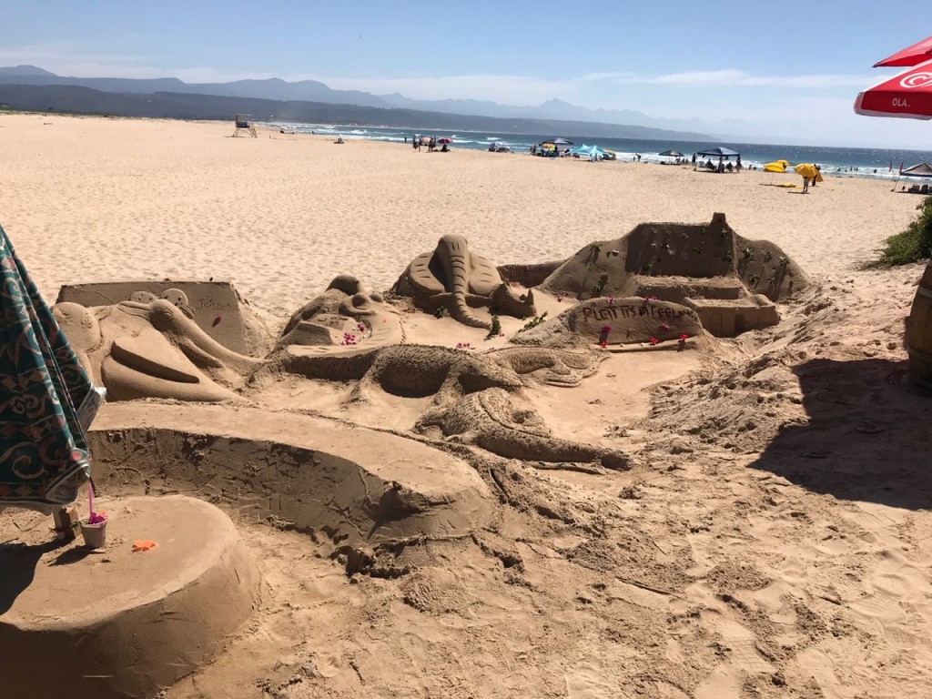 Sand art at Lookout beach, Plett, with the Tsitsikamma mountains in the background