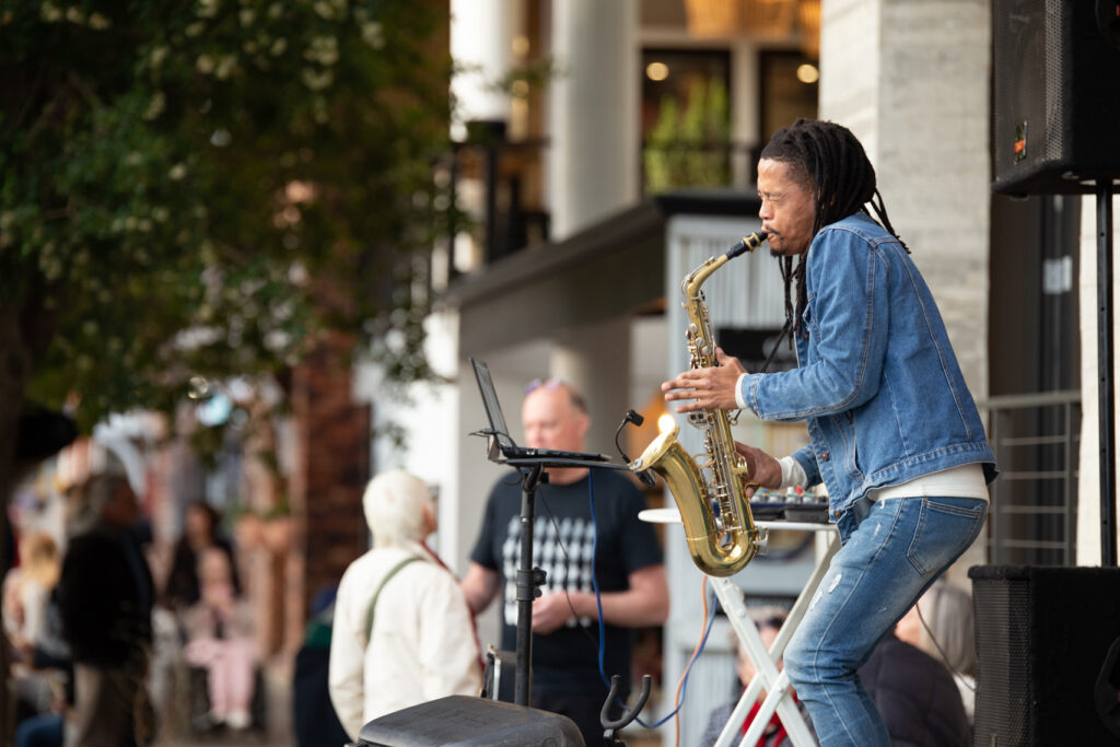 Saxophonist Janey Mitchell on the pavement at Plett ARTS Twilight Meander